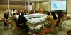 SPA colleagues sit around a horseshoe table layout facing a large screen during the hybrid Youth Dialogue event thumbnail